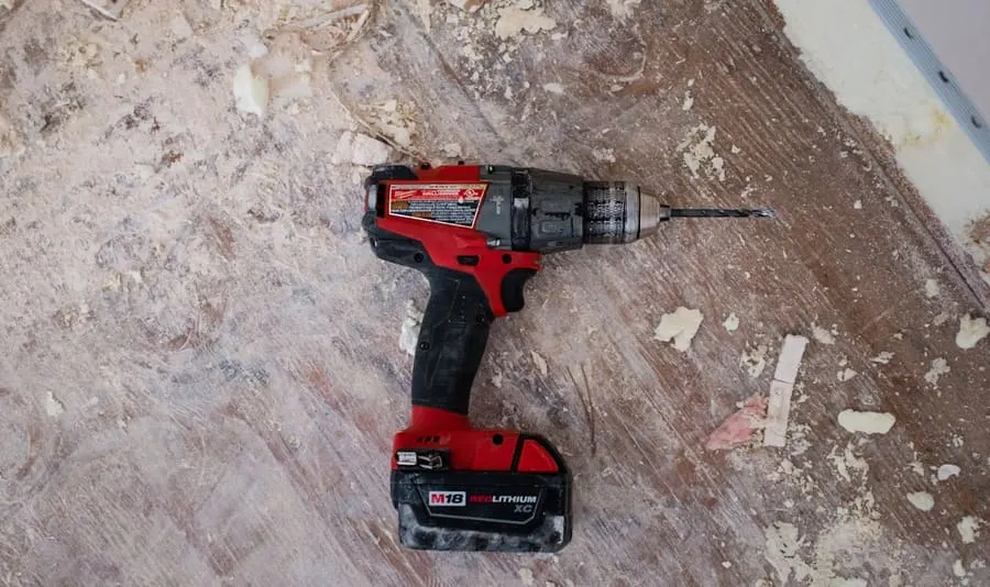 Taladro percutor a batería con mecha puesta, apoyado sobre una superficie de obra